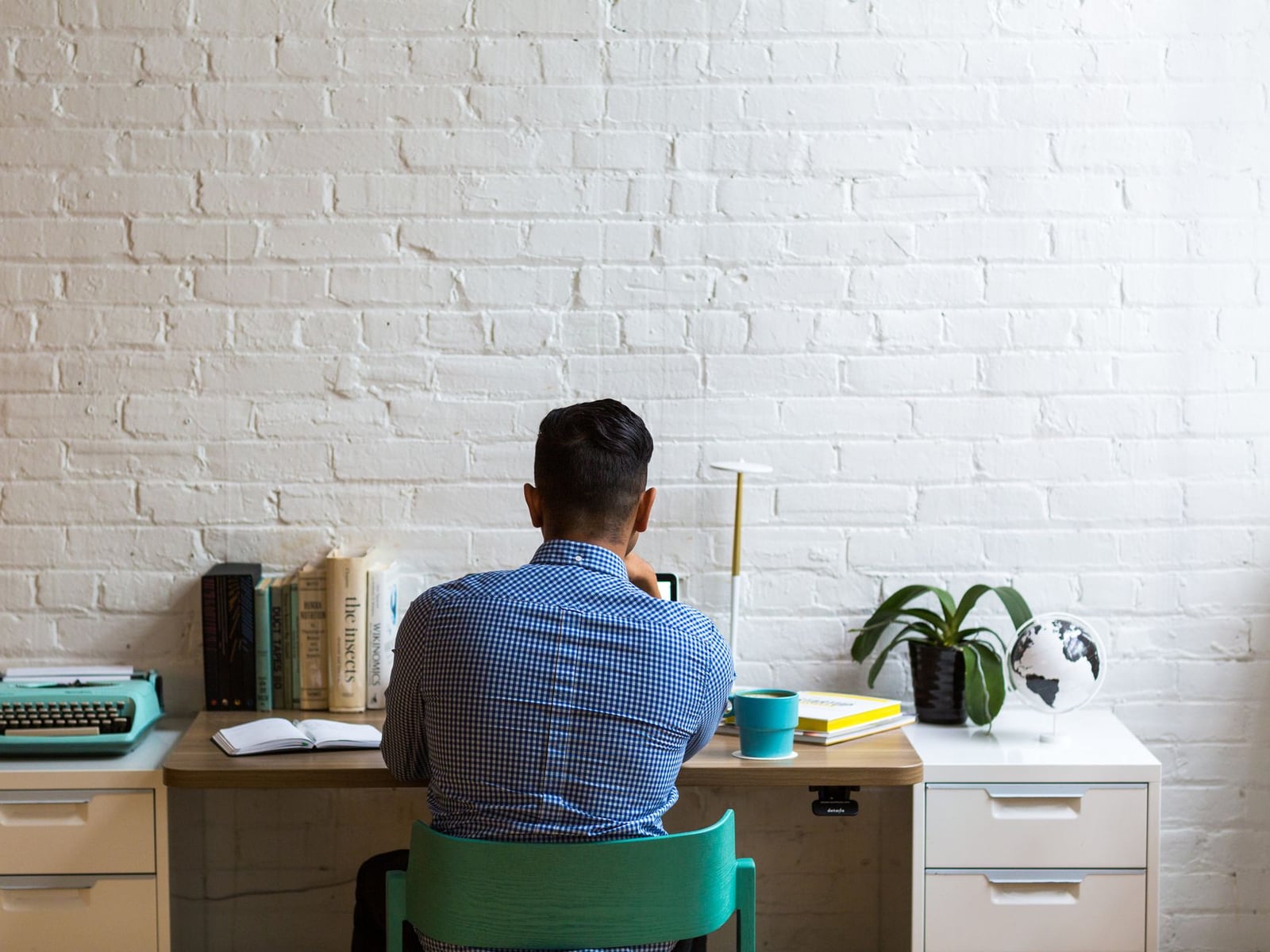 Ein minimalistischer Arbeitsplatz mit Laptop und Notizbuch für die Erstellung von Webtexten.